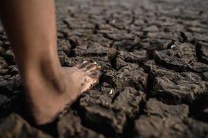 Child walking barefoot on mud photo