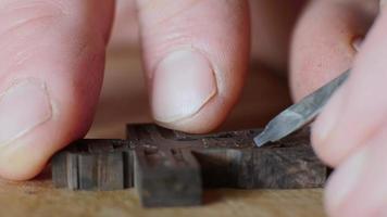 Macro de manos tallando una cruz de madera video