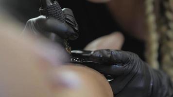 close-up van een tattoo-artiest die aan een tattoo-salon werkt video