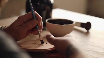 A Potter Works with A Brush in His Shop video