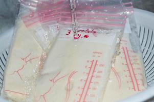 Defrosting frozen breastmilk with water photo