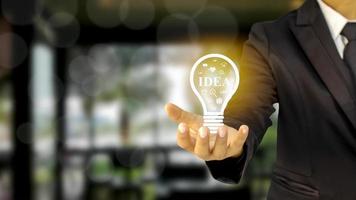 Businessman holding a light bulb idea of financial ideas, investing and running a successful business photo