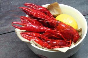 Bowl of red crawfish on wood photo