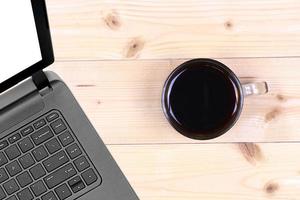 Laptop and coffee cup on wood table photo