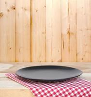 Black plate on red checkered tablecloth photo