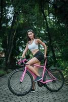 mujer montando una bicicleta rosa foto