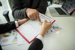 Close-up of business people working with documents photo