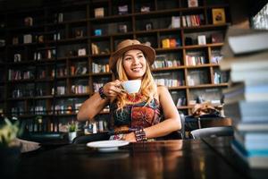 Woman drinking cappuccino and reading a book photo