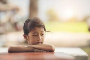 Face of a little girl sitting in the park photo