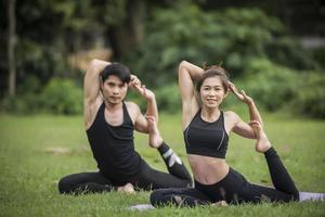 pareja haciendo yoga en el parque