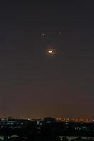 Moon and stars above a city photo