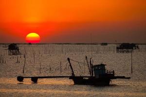 Fishing boat silhouette and a sunset photo