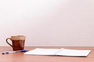 Coffee mug and notebook on the table photo