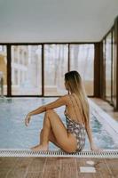 Beautiful young woman sitting by the swimming pool photo