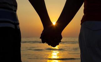 Couple holding hands at sunset photo