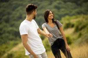 Happy young couple in love walking through grass field photo