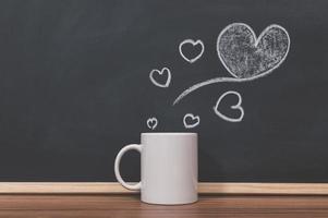 Coffee mug and heart doodle on the blackboard photo