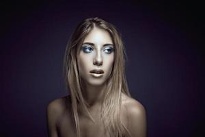 Beauty portrait of a young sexy woman against a dark blue background photo