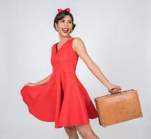 Retro fashionable woman holds luggage to travel photo