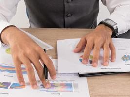 Hands of businessman working with data charts photo