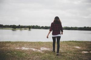 Happy hipster woman walking to the lake photo