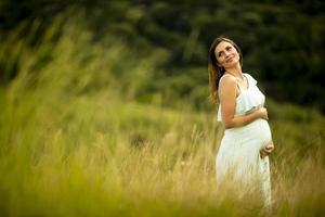 joven mujer embarazada relajarse afuera en la naturaleza foto