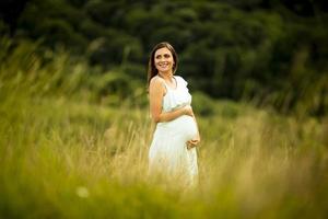 joven mujer embarazada relajarse afuera en la naturaleza foto