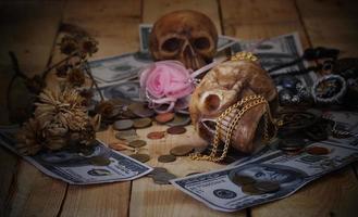 dos cráneos con dinero sobre fondo oscuro foto