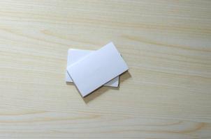 una maqueta de papel en blanco para tarjetas de visita en una mesa de madera foto