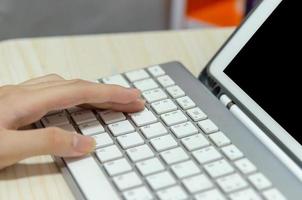 A girl using a computer keyboard studying online at home photo