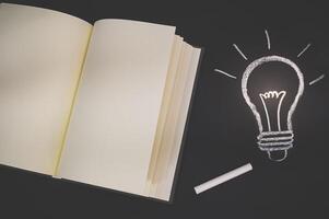 cuaderno vacío y un doodle de bombilla foto
