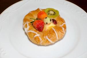 Bread, strawberries, and kiwi berries on a plate photo