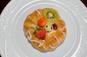 Bread, strawberries, and kiwi berries on a plate photo