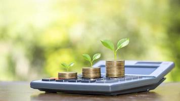 árbol en moneda y calculadora con ideas para el crecimiento financiero y el beneficio de la inversión