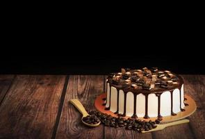 Chocolate cake with coffee beans on wooden table photo