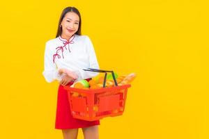 hermosa joven asiática con cesta de la compra foto