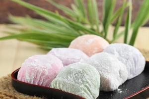 Colorful Japanese mochi dessert in black tray on wooden table photo