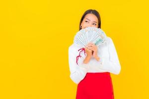 Beautiful young Asian woman sitting with a lot of cash photo