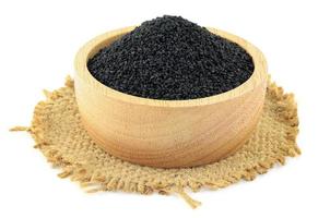Black sesame in a wooden bowl on burlap on white background