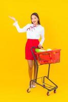 Beautiful young Asian woman with shopping cart