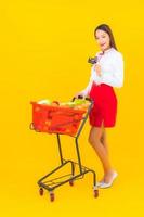 Beautiful young Asian woman with shopping cart