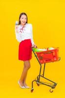 hermosa joven asiática con carrito de compras foto