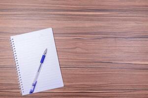 cuaderno y un bolígrafo en el escritorio foto