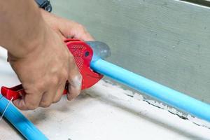 Using a cutter for plastic pipes photo