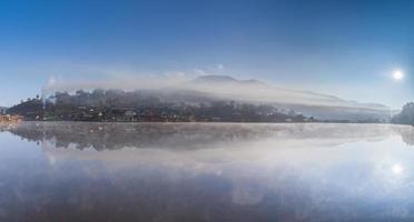 Foggy village reflected in water photo