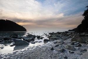 Cloudy sunset on a rocky shore photo