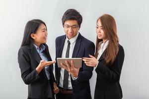 Three coworkers looking at a tablet photo