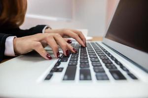 mujer escribiendo en una computadora portátil foto