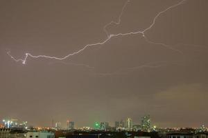 Lightening in the sky over a city photo