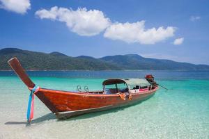 Red long boat on a beach photo